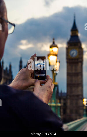 Nicht-identifizierbare im mittleren Alter weißer Mann, Foto von Londons berühmten Big Ben auf seinem Smartphone Stockfoto