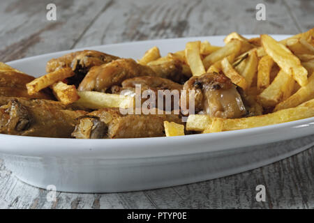 Ovale Schale gebratene Chicken Wings mit Pommes frites Stockfoto