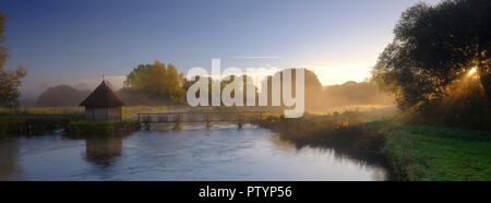 Herbst Sonnenaufgang mit Nebel auf dem Aal Haus Traps auf dem River Test in der Nähe von Longstock, Hampshire, Großbritannien Stockfoto