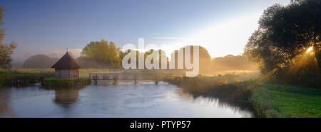 Herbst Sonnenaufgang mit Nebel auf dem Aal Haus Traps auf dem River Test in der Nähe von Longstock, Hampshire, Großbritannien Stockfoto