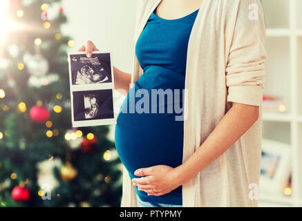 Schwangere Frau mit Ultraschall Bilder zu Weihnachten Stockfoto