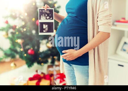 Schwangere Frau mit Ultraschall Bilder zu Weihnachten Stockfoto