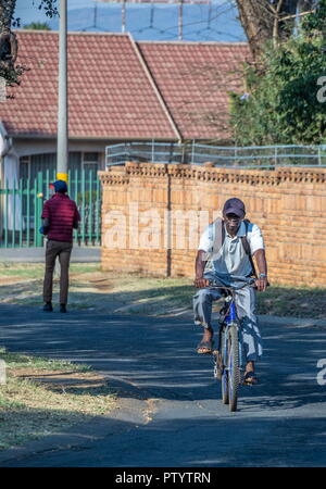 Johannesburg, Südafrika - Unbekannter schwarze Männer Wandern und Radfahren an ihre Arbeitsplätze durch die Straßen von einem Vorort Bild hat Platz kopieren Stockfoto