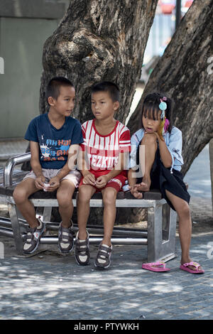 Drei junge Freunde auf einer Bank sitzen. Thailand Südostasien Stockfoto