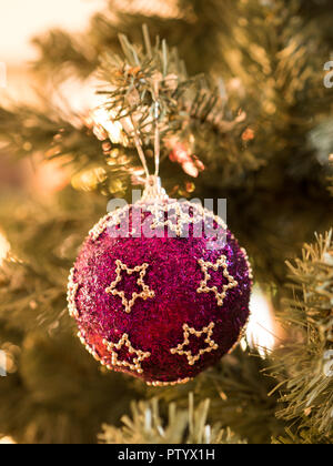 Glänzende Kugel mit Sternen auf Weihnachtsbaum Nahaufnahme Stockfoto