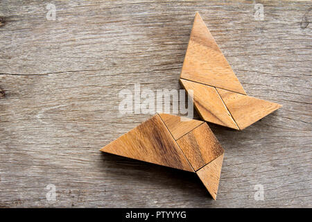 Hölzerne Tangram puzzle in fliegender Schmetterling Form Hintergrund Stockfoto