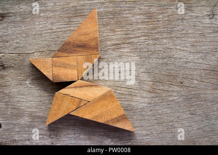 Hölzerne Tangram puzzle in fliegender Schmetterling Form Hintergrund Stockfoto