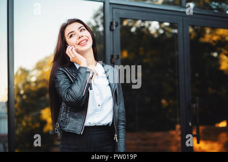 Business woman mit Smartphone close up in der Nähe des Bürogebäudes. Mädchen haben Gespräch mit Handy. Schönen kaukasischen junge Frau im Gespräch mit mob Stockfoto