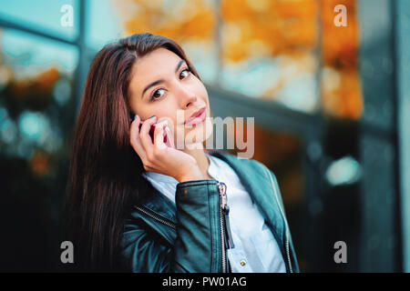 Business woman mit Smartphone close up in der Nähe des Bürogebäudes. Mädchen haben Gespräch mit Handy. Schönen kaukasischen junge Frau im Gespräch mit mob Stockfoto