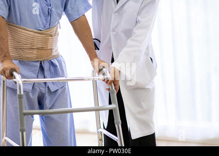 Frau Doktor helfen älteren Menschen mit erwachsenen Walker im Krankenhaus Stockfoto