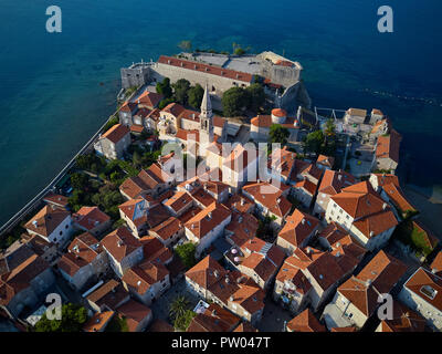 Super sonnig Stadtbild der Altstadt von Budva in Montenegro. Es ist Saint Ivan und Heilige Dreifaltigkeit Kirchen, alte Häuser mit roten Dächern, Geschindelten - orange Stockfoto