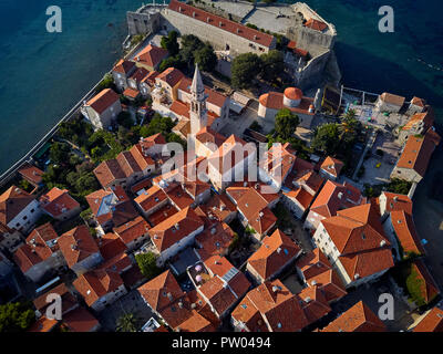 Schönen sonnigen Stadtbild der Altstadt von Budva in Montenegro. Es ist Saint Ivan und Heilige Dreifaltigkeit Kirchen, alte Häuser mit roten Geschuppt - orange Dächer, Cit Stockfoto