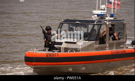 Eine maritime Durchsetzung Spezialist von der Sicherheit und der Gefahrenabwehr im Seeverkehr Team (MSST) Wellen, die Touristen an Bord der Coast Guard Cutter Richard Snyder am 23. Mai 2017. Die Crew wurde eine Sicherheitszone während der Fleet Week in New York City. (U.S. Coast Guard Foto von Auxiliarist Steven Weiß) Stockfoto