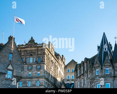 Reich verzierte Dächer der Altstadt von Edinburgh Gebäude, Cockburn Street, Edinburgh, Schottland, Großbritannien mit Military Tattoo Flagge Stockfoto