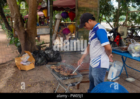 LUANG PRABANG, LAOS - OKTOBER 4: Ein unbekannter Mann gegrilltes Fleisch auf der Seite der Straße am 4. Oktober in Luang Prabang, Laos 2017. Stockfoto