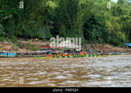 LUANG PRABANG, LAOS - OKTOBER 4: Nicht identifizierte Personen in Orange und Grün Rennen gekleidet für ein Ende der buddhistischen Fastenzeit Boat Race in Luang Prabang, Laos auf Stockfoto