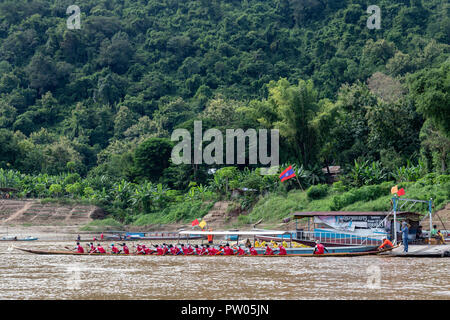 LUANG PRABANG, LAOS - OKTOBER 4: Nicht identifizierte Personen in Rot warten am Ausgangspunkt der ein Ende der buddhistischen Fastenzeit gekleidet Boat Race in Luang Prabang, Stockfoto