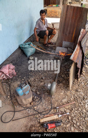 LUANG PRABANG, LAOS - OKTOBER 8: Ein unbekannter Mann rührt Kohlen auf lokaler Dorf in Luang Prabang, Laos am 8. Oktober 2017 zu schmieden. Stockfoto