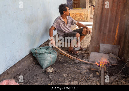 LUANG PRABANG, LAOS - OKTOBER 8: Ein nicht identifizierter heizt ein Auto teil an den lokalen Dorf in Luang Prabang, Laos am 8. Oktober 2017 zu schmieden. Stockfoto