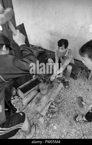 LUANG PRABANG, LAOS - OKTOBER 8: Nicht identifizierte Männer Hammer auf des Messers in einem lokalen Dorf in Luang Prabang, Laos am 8. Oktober 2017 zu schmieden. Stockfoto