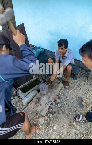 LUANG PRABANG, LAOS - OKTOBER 8: Nicht identifizierte Männer Hammer auf des Messers in einem lokalen Dorf in Luang Prabang, Laos am 8. Oktober 2017 zu schmieden. Stockfoto