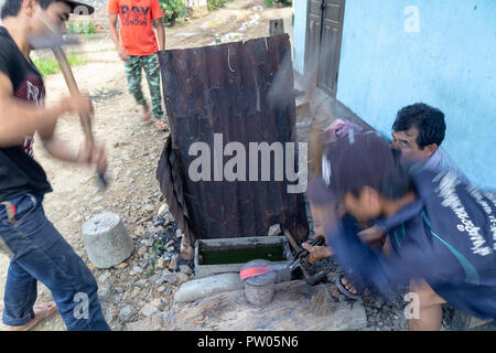 LUANG PRABANG, LAOS - OKTOBER 8: Ein unbekannter Mann schleift ein traditionelles Laos Schwert in einem lokalen Dorf in Luang Prabang, Laos am 8. Oktober, 201 Forge Stockfoto
