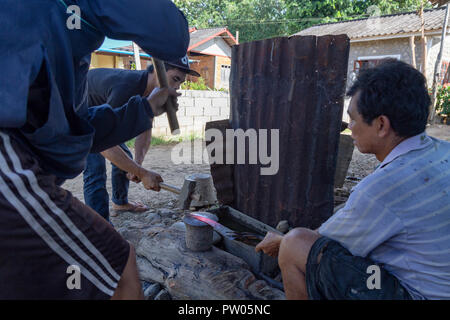 LUANG PRABANG, LAOS - OKTOBER 8: Drei unbekannte Personen ein Messer an einem lokalen Dorf Schmiede in Luang Prabang, Laos am 8. Oktober 2017 zu schmieden. Stockfoto