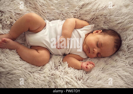 Kind schläft in einem Traum Emotionen - neugeborenes Baby Boy friedlich schlafend Stockfoto