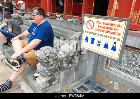 Hue Vietnam ein Besucher zu einem Tempel, in der die Kaiserliche Zitadelle seine Schuhe wieder an, nachdem Sie den Tempel betreten mit nahe gelegenen Dress Code beachten Stockfoto