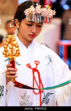 Japanische neues Jahr, shogatsu. Shrine Maiden, Miko, mit Kopfbedeckung der Blumen, die Teil einer Segen Zeremonie am Ikuta Shinto Schrein in Kobe Stockfoto