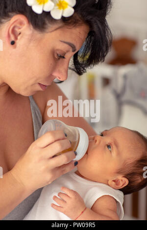 Mutter gibt Wasser baby boy von der Flasche zu trinken Stockfoto