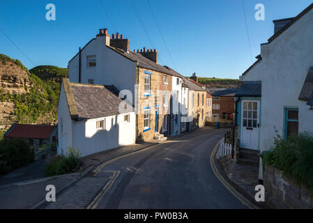 Schmale Gasse hinunter zum Fluss im historischen Dorf Staithes an der Küste von North Yorkshire, England. Stockfoto