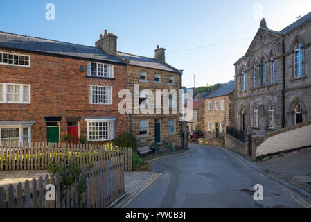 Straße in der malerischen und historischen Dorf Staithes an der Küste von North Yorkshire, England. Captain Cook Museum auf der rechten Seite. Stockfoto