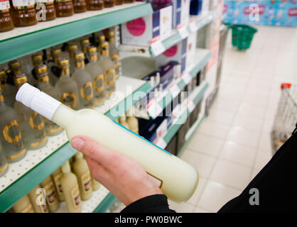 Der Käufer wählt das alkoholische Getränk an der Hand ein Mann im Store. Stockfoto