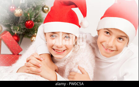 Kinder posieren mit Weihnachtsmütze im Studio Stockfoto