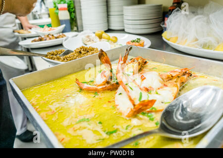 Besetzt die Mittagspause im Restaurant - gebackene Tiger Garnelen in Butter Soße im Vordergrund. Stockfoto