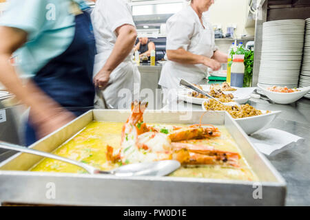 Besetzt die Mittagspause im Restaurant - gebackene Tiger Garnelen in Butter Soße im Vordergrund. Stockfoto