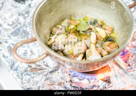 Teil der Muscheln gebraten mit Knoblauch in Olivenöl in einem Topf auf Gas Herd Stockfoto