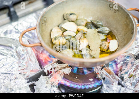 Teil der Muscheln mit Lorbeerblättern und Knoblauch in einem Topf auf Gas Herd Stockfoto