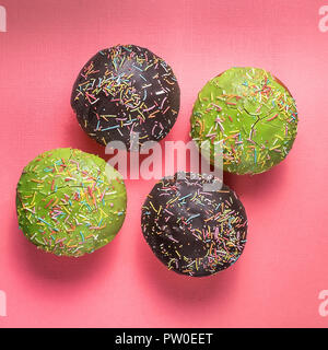Flach auf Schokolade Donuts auf rosa Hintergrund. Stockfoto