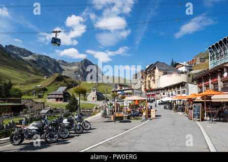 Geparkte Motorräder und Touristen in Cafés/Bars im Dorf La Mongie, Winter Skigebiet in Campan, Hautes-Pyrénées, Frankreich Stockfoto