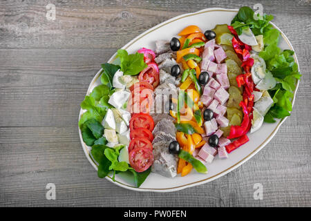 Ein beliebtes Gericht der amerikanischen Küche - Cobb Salat, bestehend aus grünen, Eier, Tomaten, Käse, Fleischwaren, in Reihen gestapelt auf eine große Schüssel und poure Stockfoto