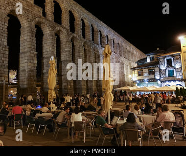 Nachtleben in Plaza Azoguejo an den Bögen der historischen alten römischen Aquädukt in Segovia, Spanien. Stockfoto