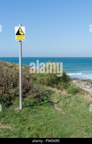 Warnschild "Cliff Danger" - mit Mann über Klippe, Klippenrand. Vom Kantenkonzept fernhalten, abfallen, herabfallendes Mannpiktogramm. Stockfoto