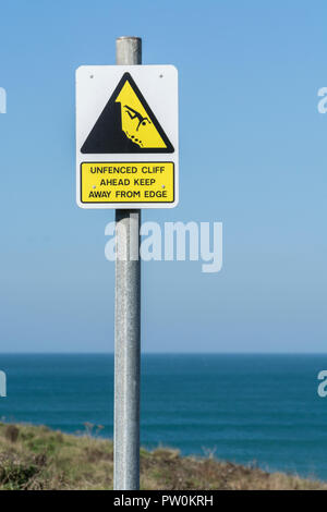 Warnschild "Cliff Danger" - mit Mann über Klippe, Klippenrand. Vom Kantenkonzept fernhalten, abfallen, herabfallendes Mannpiktogramm. Stockfoto