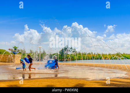 Grand Cayman, Cayman Islands, Kinder spielen durch ein Brunnen auf der Plaza von Camana Bay ein modernes waterfront Stadt in der Karibik Stockfoto