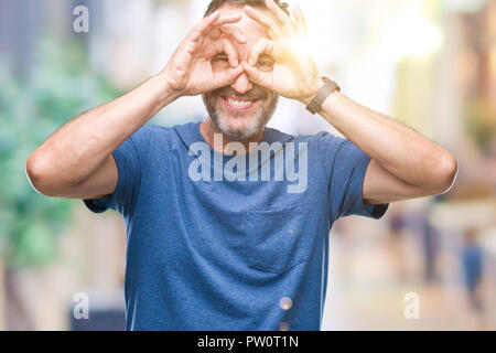 Mittleres Alter hoary älterer Mann über isolierte Hintergrund tun ok Geste wie Fernglas Zunge heraus, Augen durch die Finger schauen. Crazy Express Stockfoto