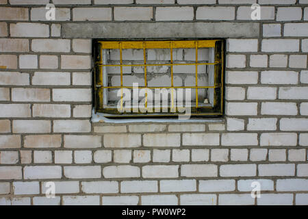 Weiße Mauer mit gelben Grill in Cesis, Lettland. Stockfoto