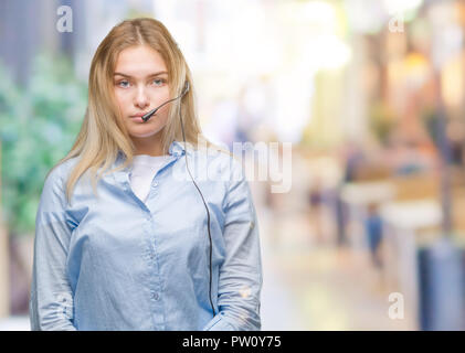 Junge kaukasier Business woman tragen Call center Headset über isolierte Hintergrund mit ernsten Gesichtsausdruck. Einfach und natürlich mit Blick auf die Stockfoto