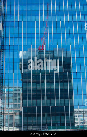 Spiegelbild der hohen Anstieg und hohes Gebäude Projekt im Fenster eines anderen Entwicklung und Regeneration Projekt in der Greenwich Gegend von London, Großbritannien Stockfoto